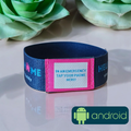 Navy blue and pink emergency wristband with Android logo on a reflective surface with flowers in the background