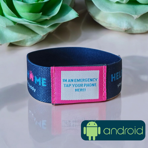 Navy blue and pink emergency wristband with Android logo on a reflective surface with flowers in the background